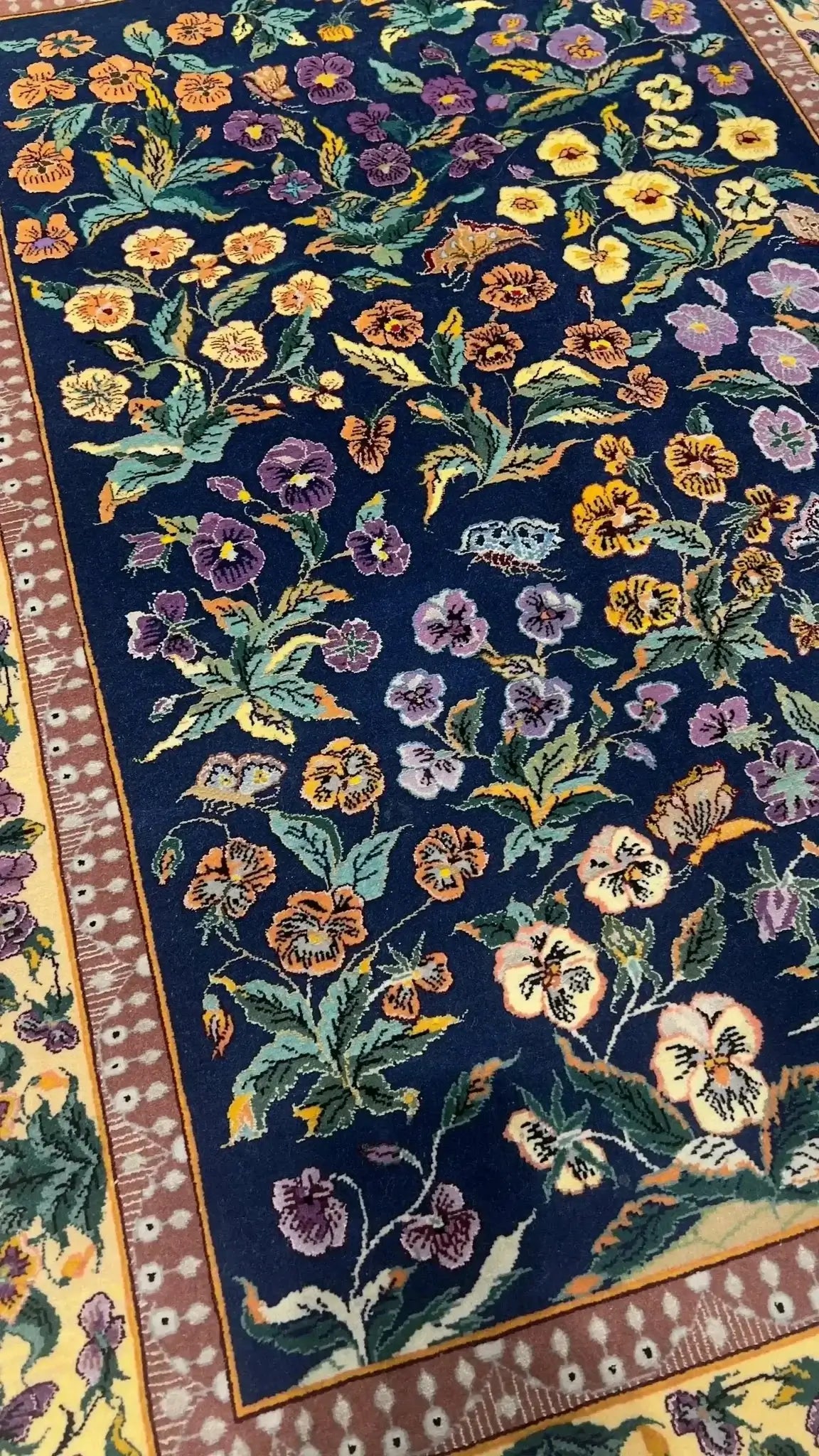 Hand-knotted wool and silk rug with a navy-blue base.